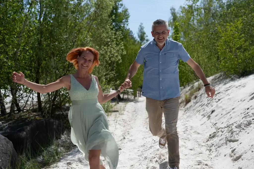 Couple qui court dans un chemin de sable blanc dans l’Aisne lors d’une séance engagement