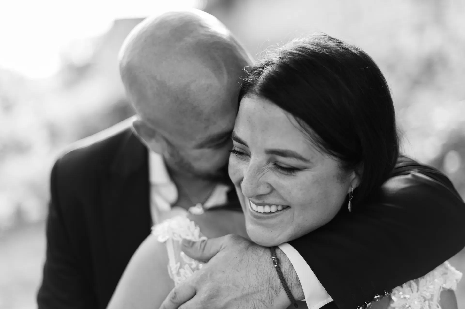 Marié enlaçant tendrement la mariée souriante, photo de mariage en noir et blanc, photographe Reims