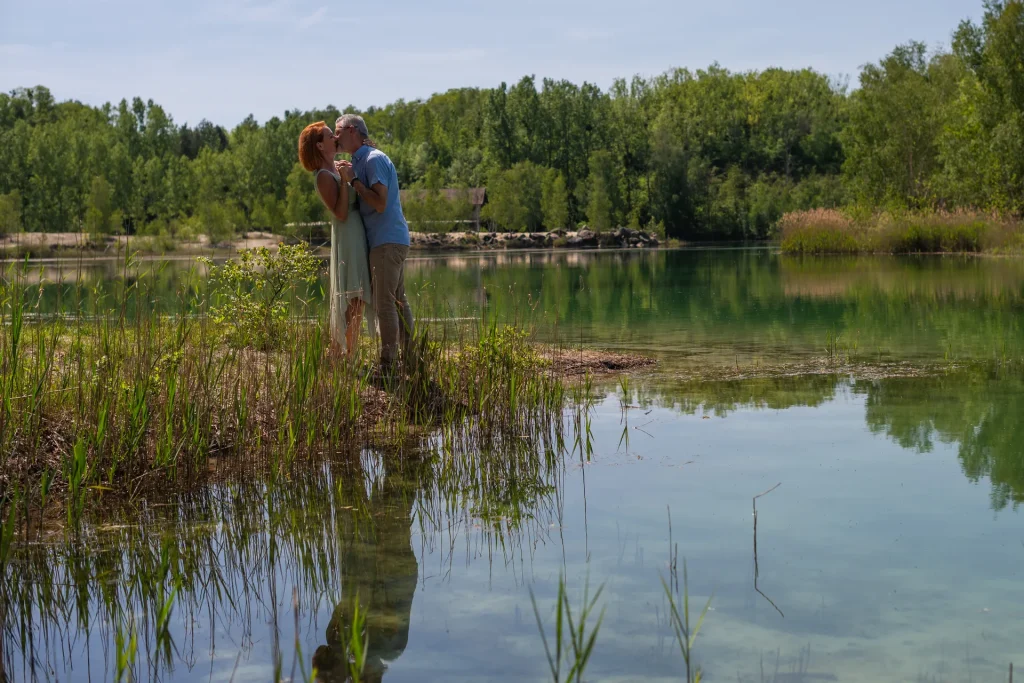 Couple enlacé devant un lac dans l’Aisne lors d’une séance engagement