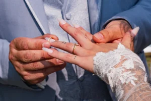 Le marié passe l'alliance au doigt de sa femme durant la cérémonie laïque.